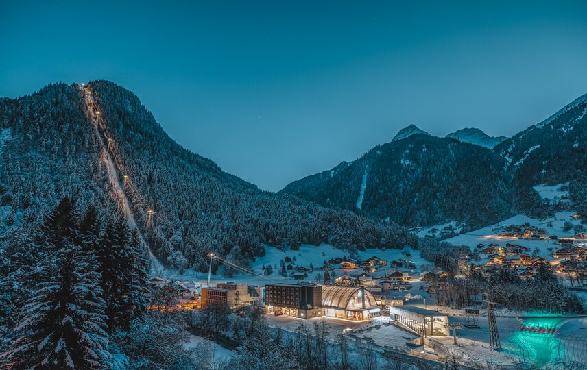 Die Valisera Bahn erleuchtet bei Nacht mit schneebdeckten Bäumen und Bergspitzen | © Silvretta Montafon - Mathäus Gartner