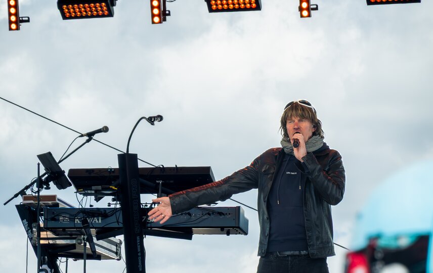 Mickie Krause in schwarzer Bekleidung singt auf der Bühne in den Bergen | © Silvretta Montafon - VONIHR Productions