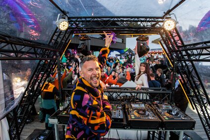 Sebastian Bronk vor einer großen Menge in einer bunten Jacke | © Silvretta Montafon - Sebastian Bronk