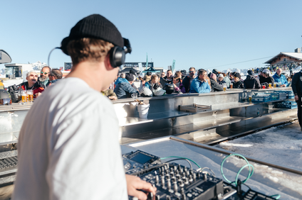 Ein DJ spielt in der Bella Nova währenddessen die Skifahrer ein Getränk genießen | © Silvretta Montafon - Marie Schilcher