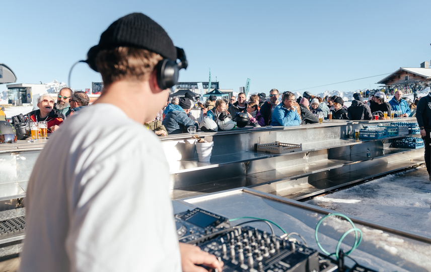 Ein DJ spielt in der Bella Nova währenddessen die Skifahrer ein Getränk genießen | © Silvretta Montafon - Marie Schilcher