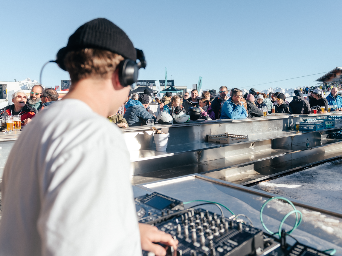 Skiopening Montafon - Silvretta Montafon | © Silvretta Montafon - Marie Schilcher Ein DJ spielt in der Bella Nova währenddessen die Skifahrer ein Getränk genießen | © Silvretta Montafon - Marie Schilcher