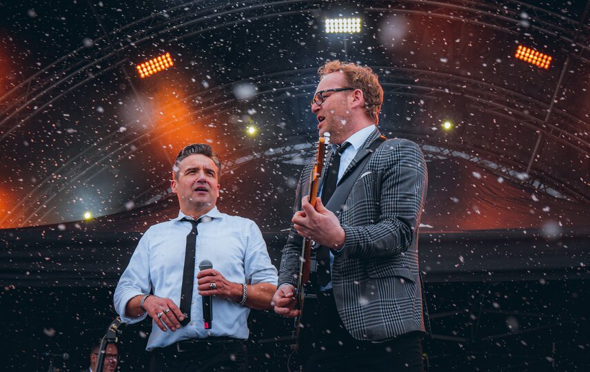 Ein Gitarrist und ein Sänger gemeinsam auf der Bühne währenddessen es schneit | © Silvretta Montafon - Robin Mayer