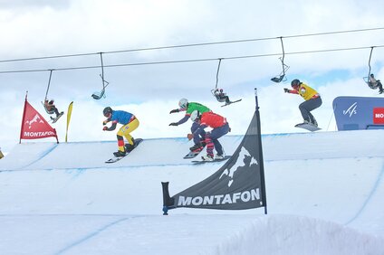 Vier Snowboardcross Fahrer auf der Strecke beim Weltcup Montafon | © Silvretta Montafon - Marie Schilcher