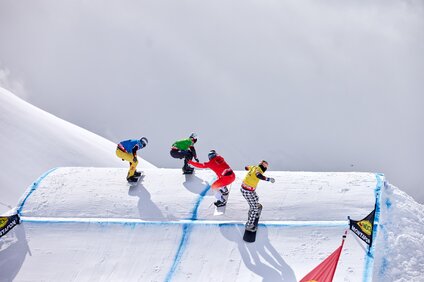Vier Snowboardprofis fahren auf der Strecke des FIS Snowboard Cross Weltcup in der Silvretta Montafon. | © Montafon Tourismus - Stefan Kothner