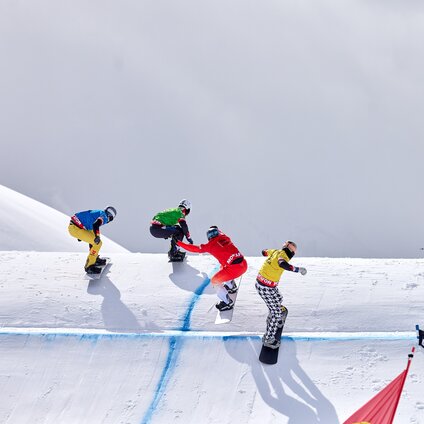 Vier Snowboardprofis fahren auf der Strecke des FIS Snowboard Cross Weltcup in der Silvretta Montafon. | © Montafon Tourismus - Stefan Kothner