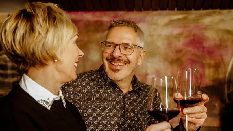 Zwei Personen stoßen mit einem Glas Rotwein an beim Winzerabend in der VINNOVA im Skigebiet Silvretta Montafon. | © Vanessa Strauch - Silvretta Montafon