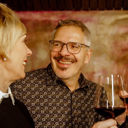 Zwei Personen stoßen mit einem Glas Rotwein an beim Winzerabend in der VINNOVA im Skigebiet Silvretta Montafon. | © Vanessa Strauch - Silvretta Montafon