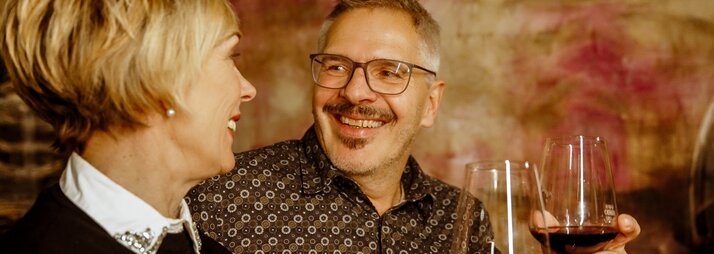 Zwei Personen stoßen mit einem Glas Rotwein an beim Winzerabend in der VINNOVA im Skigebiet Silvretta Montafon. | © Vanessa Strauch - Silvretta Montafon