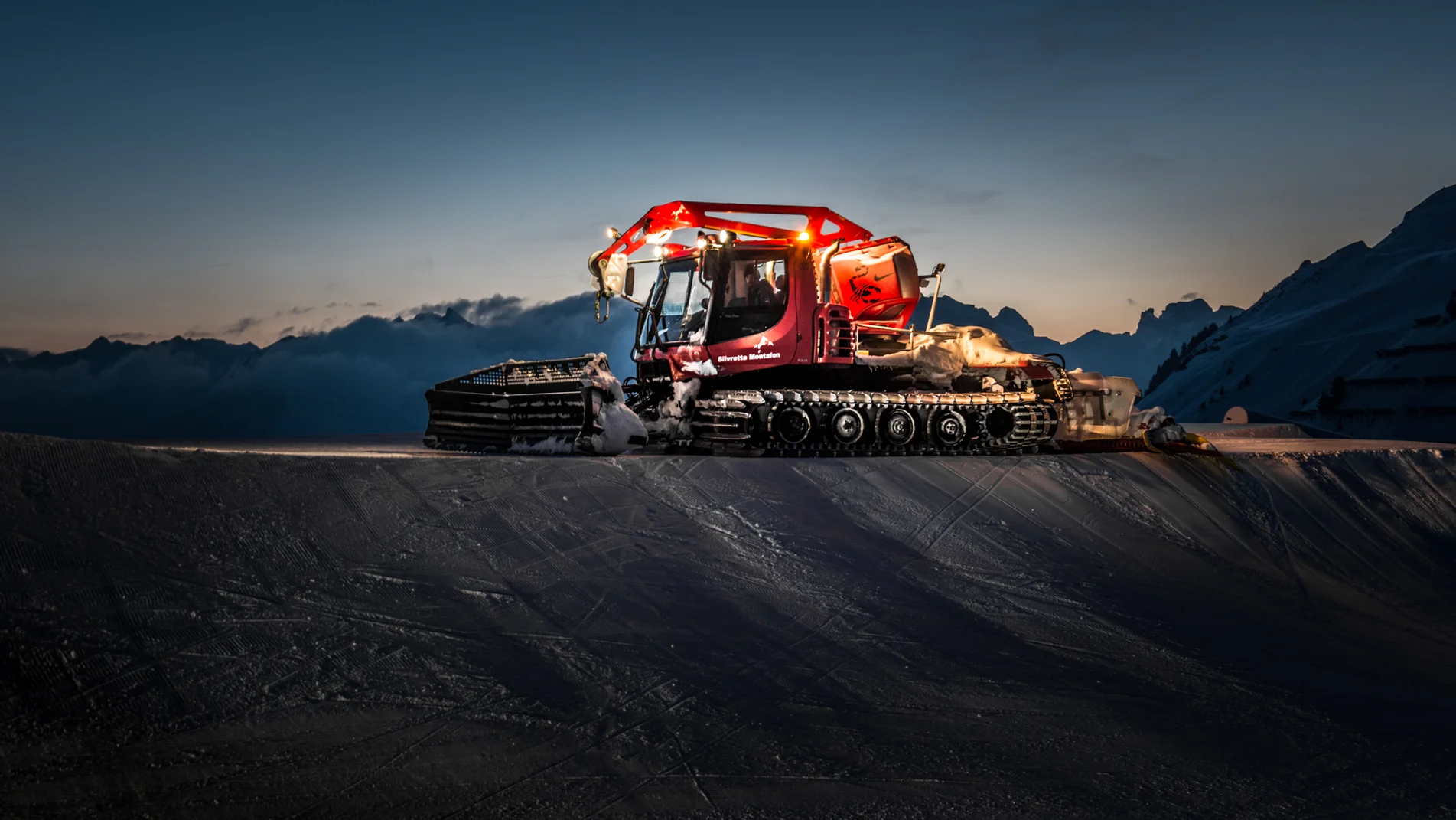 Pistenbully - Silvretta Montafon | © Silvretta Montafon Ein roter Pistenbully in einer Abendszenerie in der Silvretta Montafon | © Silvretta Montafon