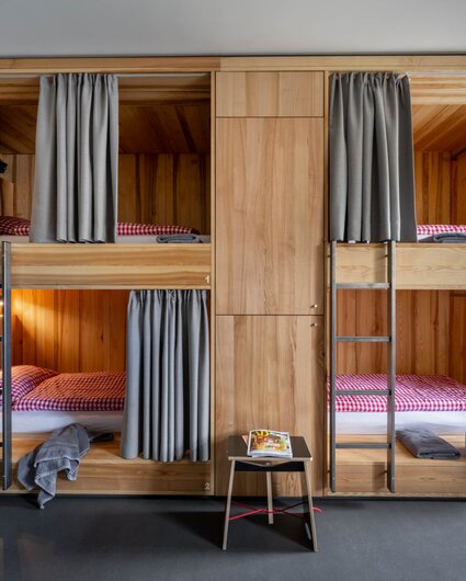 Ein Bett im Mehrbettzimmer mit zwei Stockebetten im Josefsheim Hostel in Schruns. | © Silvretta Montafon - blateral