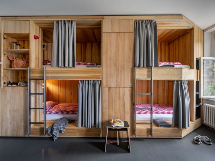 Ein Bett im Mehrbettzimmer mit zwei Stockebetten im Josefsheim Hostel in Schruns. | © Silvretta Montafon - blateral