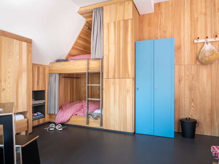 Ein Bett im Mehrbettzimmer mit Stockbett und Kleiderschrank im Josefsheim Hostel in Schruns. | © Silvretta Montafon - blateral