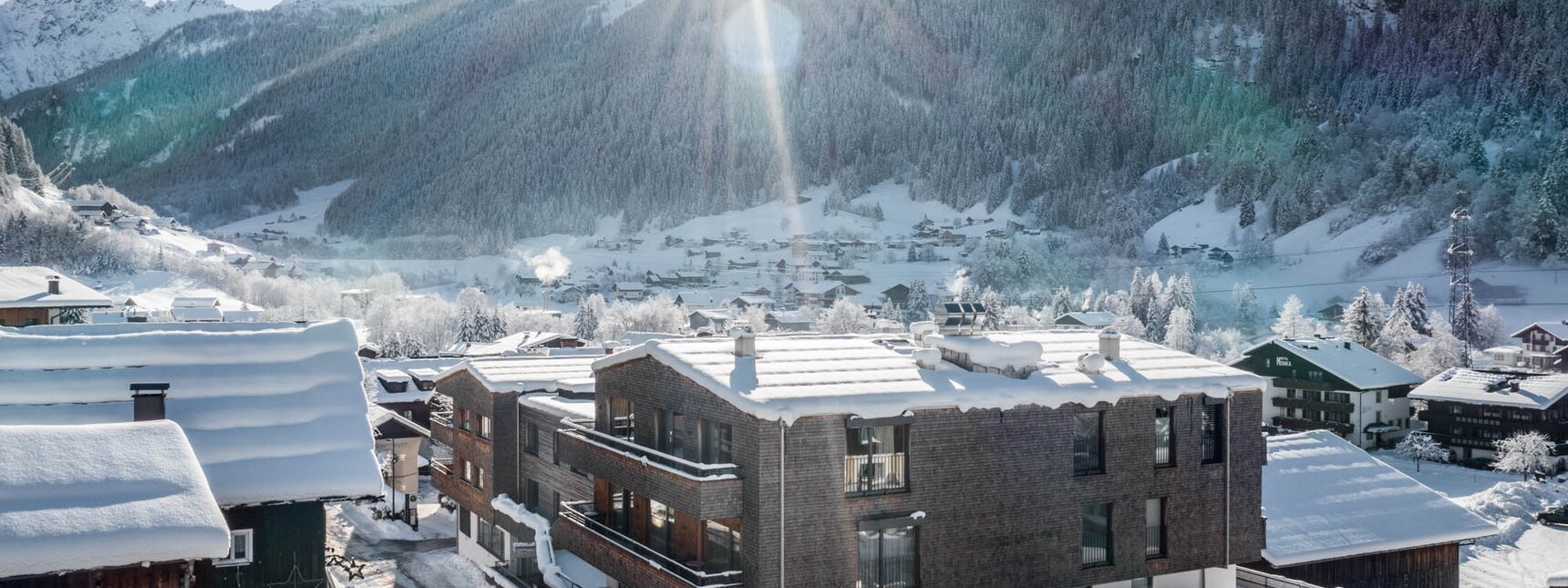 Aussenansicht Chalets und verschneite Landschaft in Gaschurn. | © Silvretta Montafon - blateral