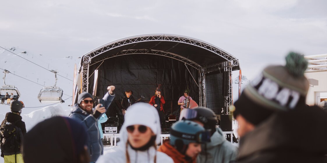 Eine Bühne mit Musikern spielt auf der Nova Stoba Terrasse bei einem Apés-Ski Event. | © Silvretta Montafon - WanderlustAllgäu 