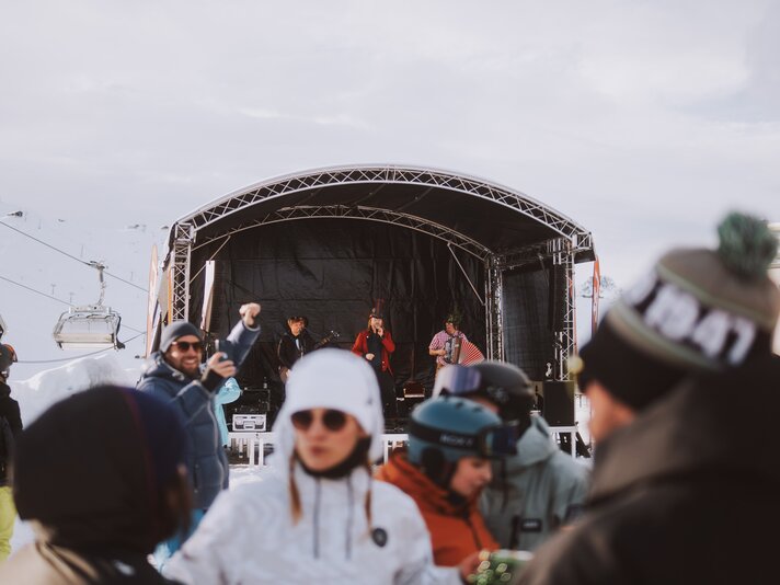 Eine Bühne mit Musikern spielt auf der Nova Stoba Terrasse bei einem Apés-Ski Event. | © Silvretta Montafon - WanderlustAllgäu 