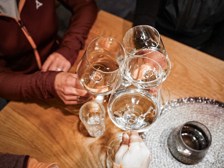 Drei Weingläser beim Anstossen in der Weinbar im Silvretta Park Montafon. | © Silvretta Montafon - Vanessa Strauch