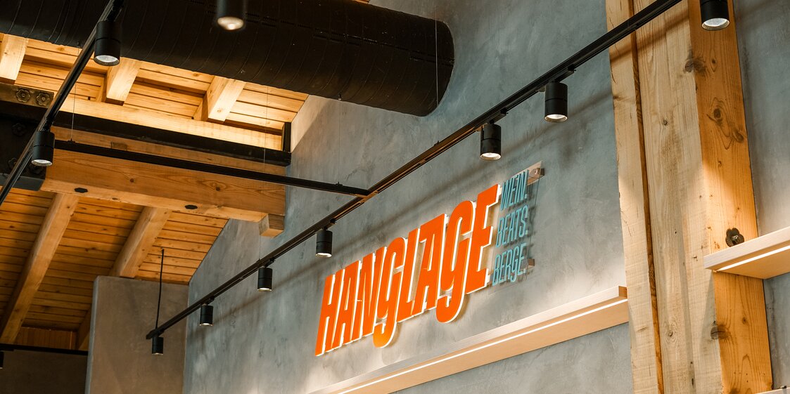 Der orange beleuchtetet Schriftzug des Restaurants Hanglage am Hochjoch. | © Silvretta Montafon - Vanessa Strauch