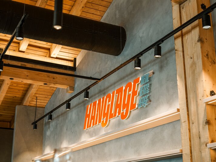 Der orange beleuchtetet Schriftzug des Restaurants Hanglage am Hochjoch. | © Silvretta Montafon - Vanessa Strauch