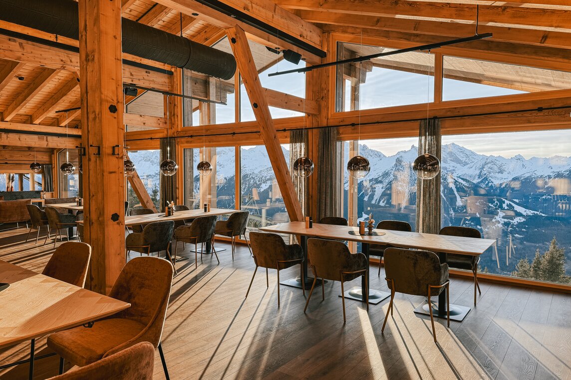 Ein gedeckter Tisch mit Aussicht über die verschneiten Berge in der Hanglage im Kapellrestaurant in der Silvretta Montafon. | © Silvretta Montafon - Vanessa Strauch