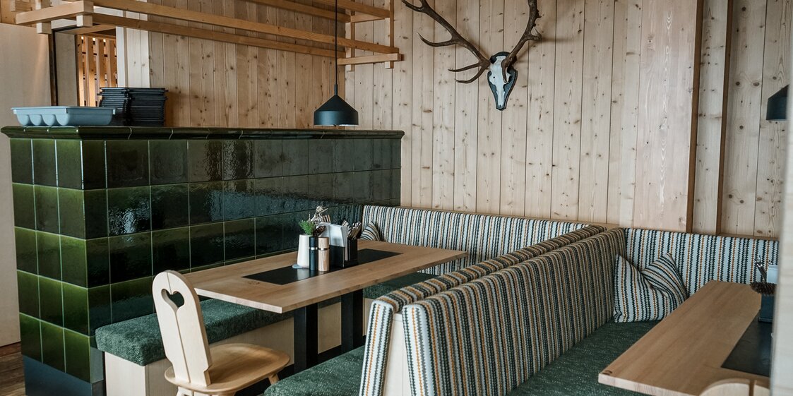 Eine gemütliche Stube mit Holztischen und Kamin im Kapellrestaurant in der Silvretta Montafon. | © Silvretta Montafon - Vanessa Strauch
