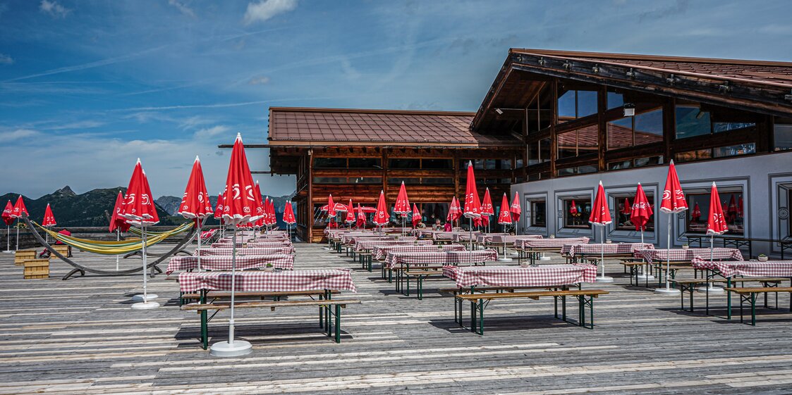 Die Sonnenterrasse des Kapellrestaurants mit Bierbänken und Sonnenschirmen. | © Silvretta Montafon