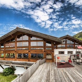 Die Aussenansicht des Kapellrestaurants im Sommer mit Spielplatz auf der Terrasse. | © Silvretta Montafon - Stefan Kothner