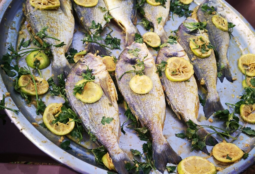 Fische mit Zitronen garniert auf einem Silberteller präsentiert | © Silvretta Montafon