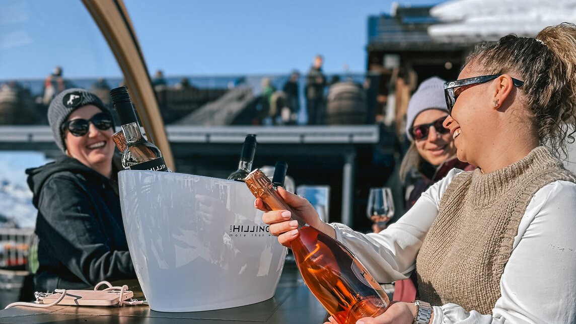 Drei Frauen stehen an einer Weinbar auf einer Terrassse im Skigebiet Silvretta Montafon. | © Vanessa Strauch - Silvretta Montafon