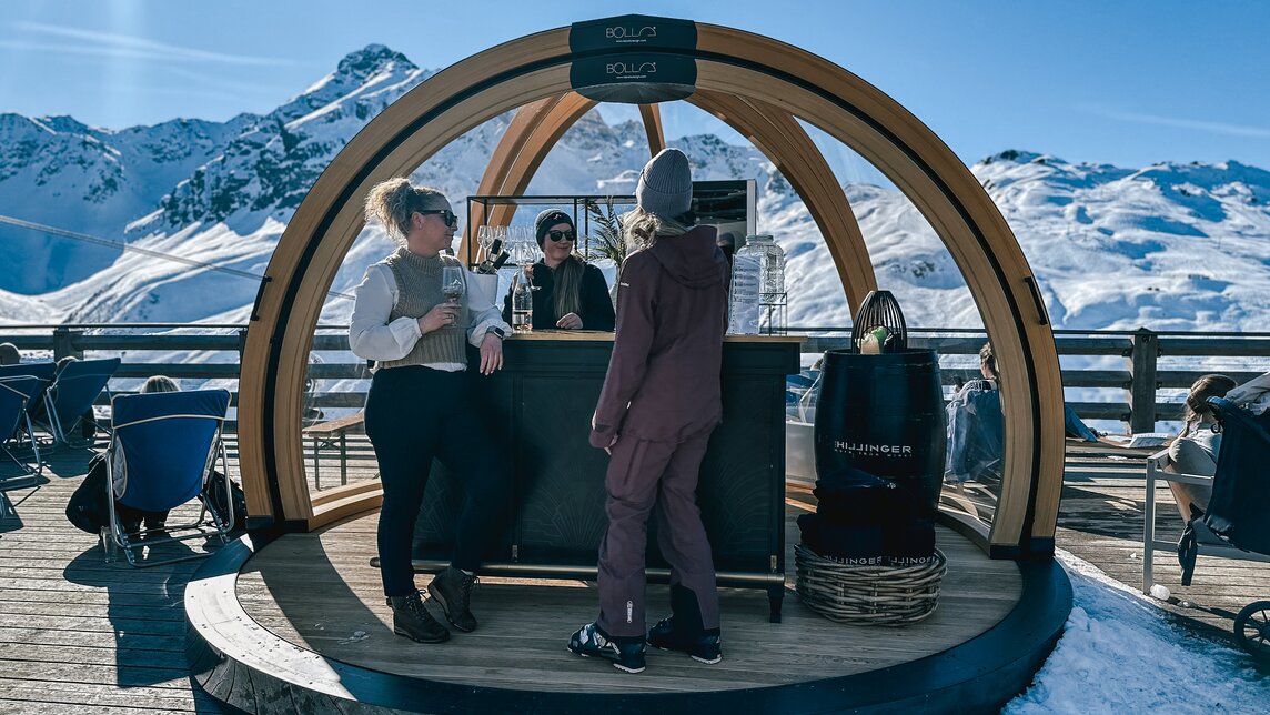 Drei Frauen stehen an einer Weinbar auf einer Terrassse im Skigebiet Silvretta Montafon. | © Vanessa Strauch - Silvretta Montafon