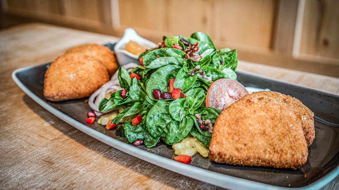 Ein Teller mit gebackenen Kässpätzli und Salat in der Nova Stoba. | © Silvretta Montafon - Vanessa Strauch