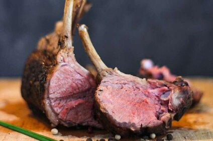 Eine Keule vom Montafoner Steinschaf mit Pfefferkerner auf einem Holzbrett. | © Silvretta Montafon - Anna Wittwer