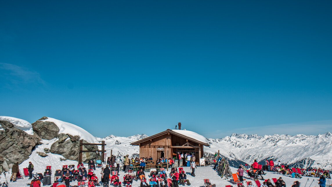 Das Schwarzköpfli Kiosk bei schönem Wetter mit vielen Liegestühlen und Wintersportlern. | © Silvretta Montafon - Daniel Zangerl