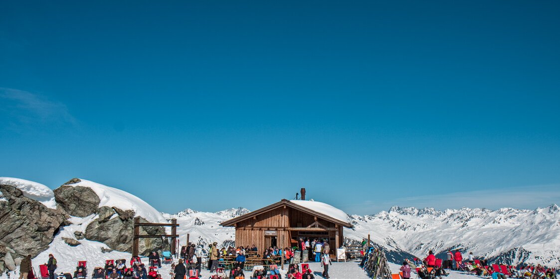 Das Schwarzköpfli Kiosk bei schönem Wetter mit vielen Liegestühlen und Wintersportlern. | © Silvretta Montafon - Daniel Zangerl
