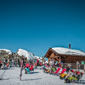 Das Schwarzköpfli Kiosk bei schönem Wetter mit vielen Liegestühlen und Wintersportlern. | © Silvretta Montafon - Daniel Zangerl