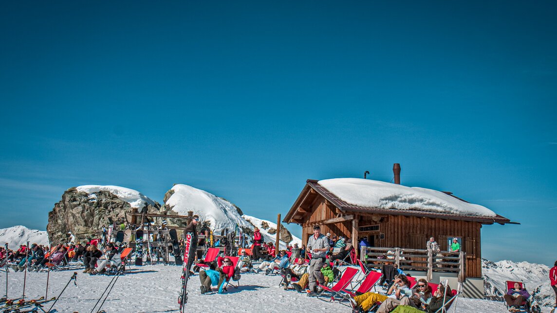 Das Schwarzköpfli Kiosk bei schönem Wetter mit vielen Liegestühlen und Wintersportlern. | © Silvretta Montafon - Daniel Zangerl