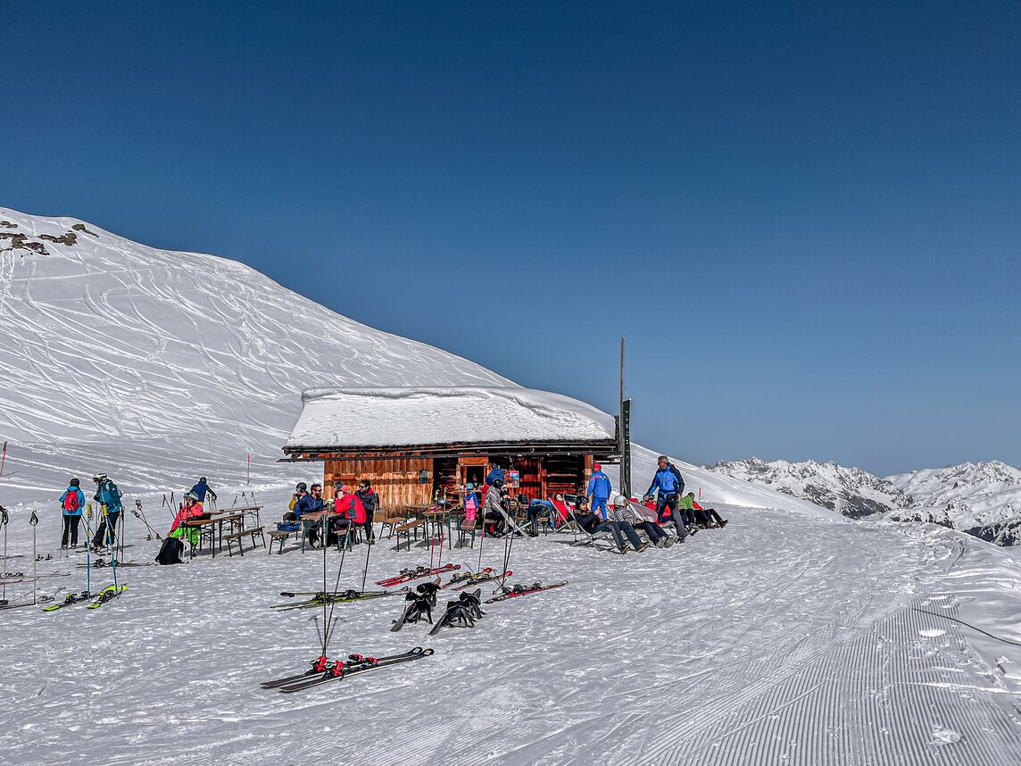 Eine Berghütte im Skigebiet mit Liegestühlen direkt an der Piste. | © Silvretta Montafon - Vanessa Strauch