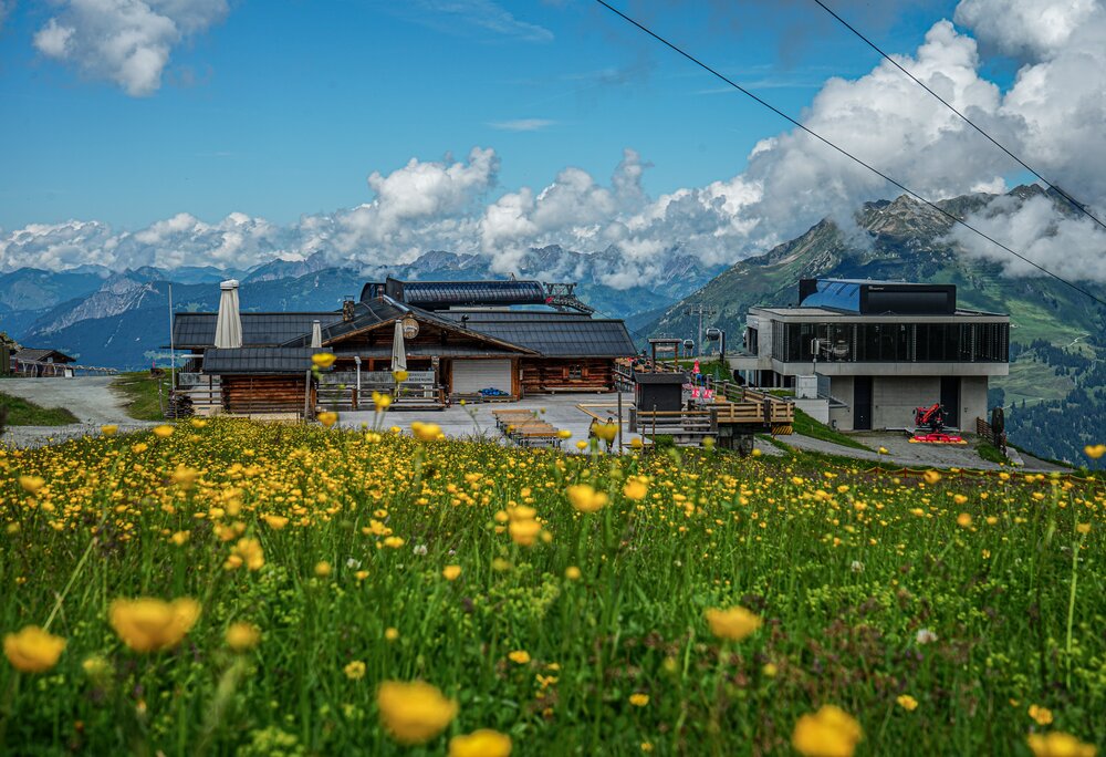 Das Valisera Hüsli von vorne mit der Bergstation der Valisera Bahn im Hintergrund | © Silvretta Montafon - Vanessa Strauch