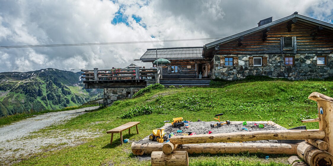 Ein Sandkasten mi Spielzeug vor dem Valisera Hüsli in der Silvretta Montafon | © Silvretta Montafon - Vanessa Strauch