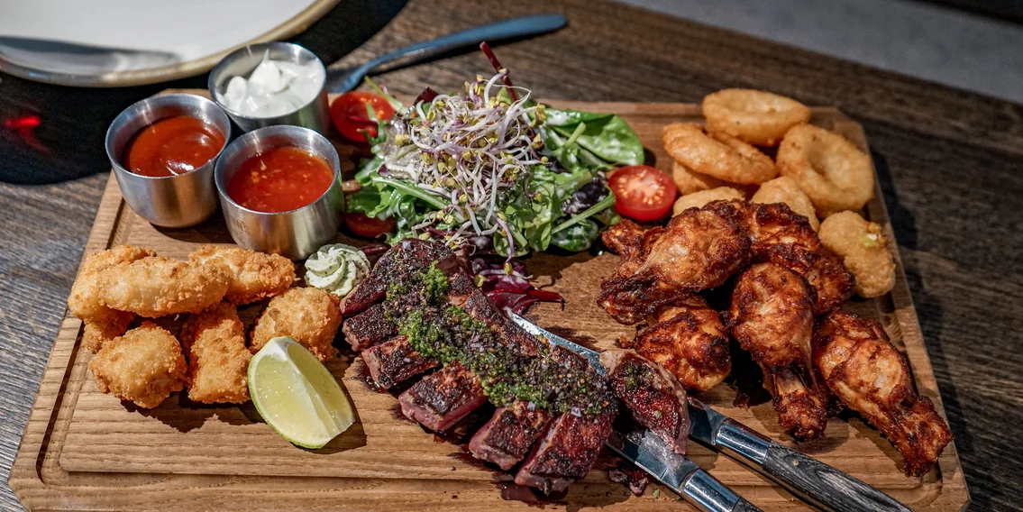 Ein Brett mit verschiedenen Tapas und Soßen in der Alten Talstation. | © Silvretta Montafon - Vanessa Strauch