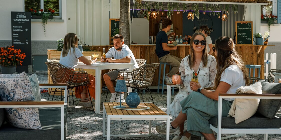Menschen genießen ihre kühlen Cocktails im St. Josefs Cocktailgarten im Sommer | © Silvretta Montafon - Vanessa Strauch
