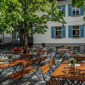 Zwei Frauen an einem Tisch im Gastgarten mit Kaffee und Kuchen im Josefsheim in Schruns. | ©  Silvretta Montafon - Vanessa Strauch
