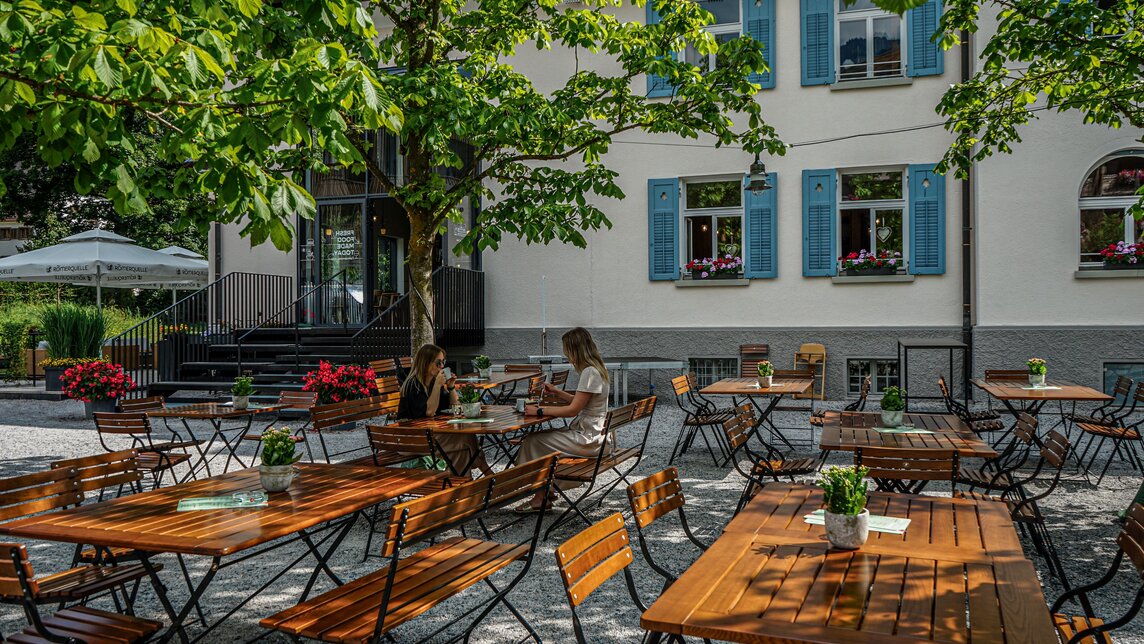 Zwei Frauen an einem Tisch im Gastgarten mit Kaffee und Kuchen im Josefsheim in Schruns. | ©  Silvretta Montafon - Vanessa Strauch