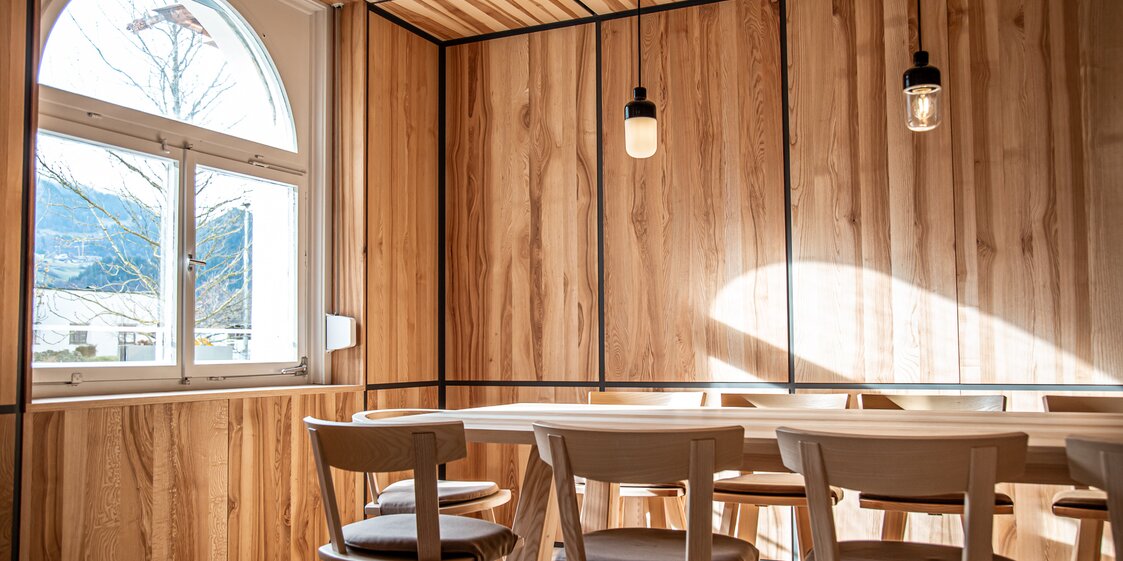 Ein Tisch mit Stühlen aus Holz im Restaurant. | © Silvretta Montafon - Frederike Weber