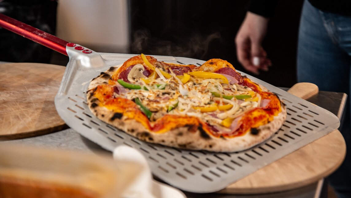 Eine Pizza frisch aus dem Pizzaofen. | © Silvretta Montafon - Friederike Weber