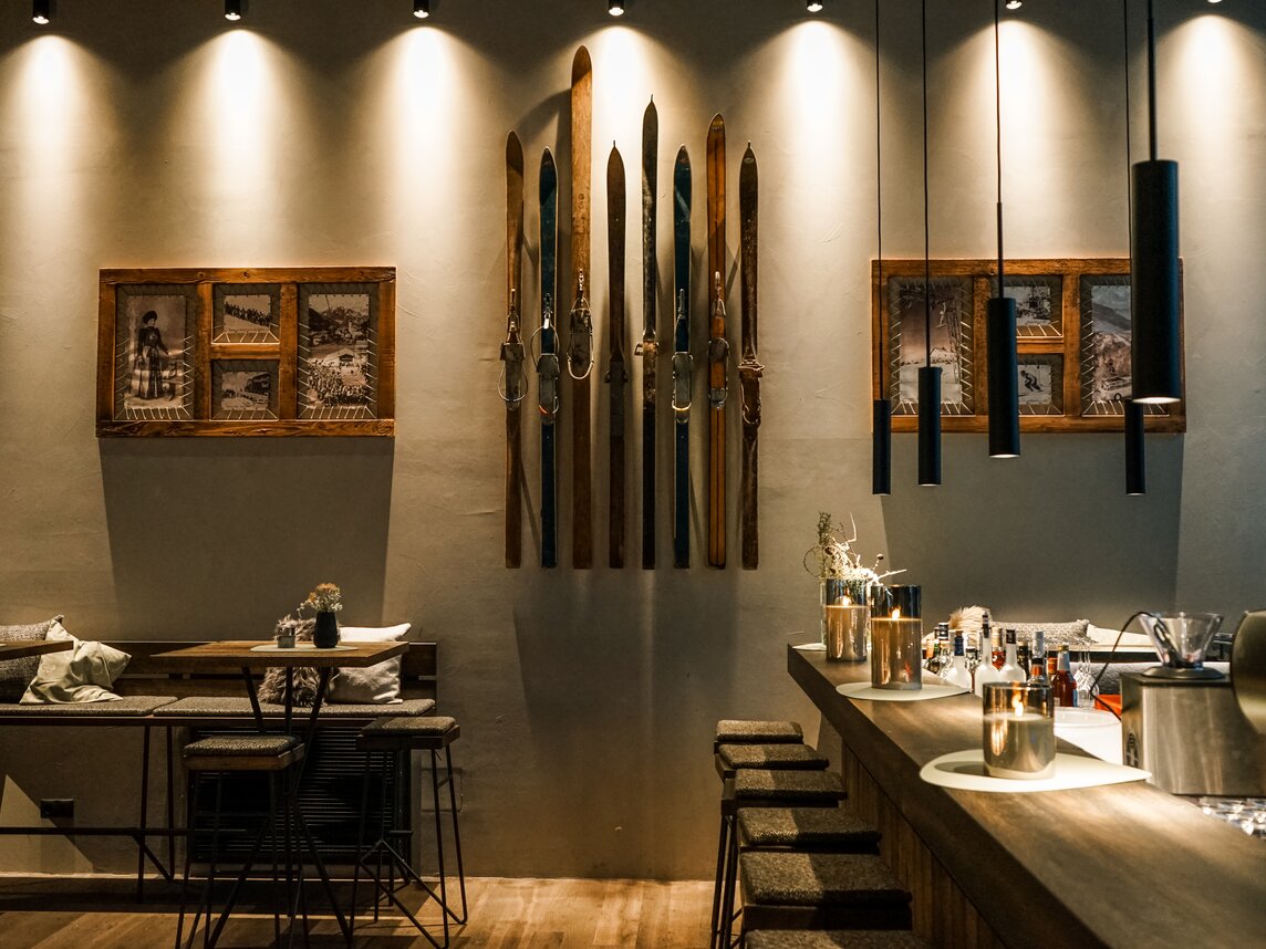 Ein Theke und ein Tisch im Restaurant, alte Ski hängen an der Wand. | © Silvretta Montafon - Vanessa Strauch
