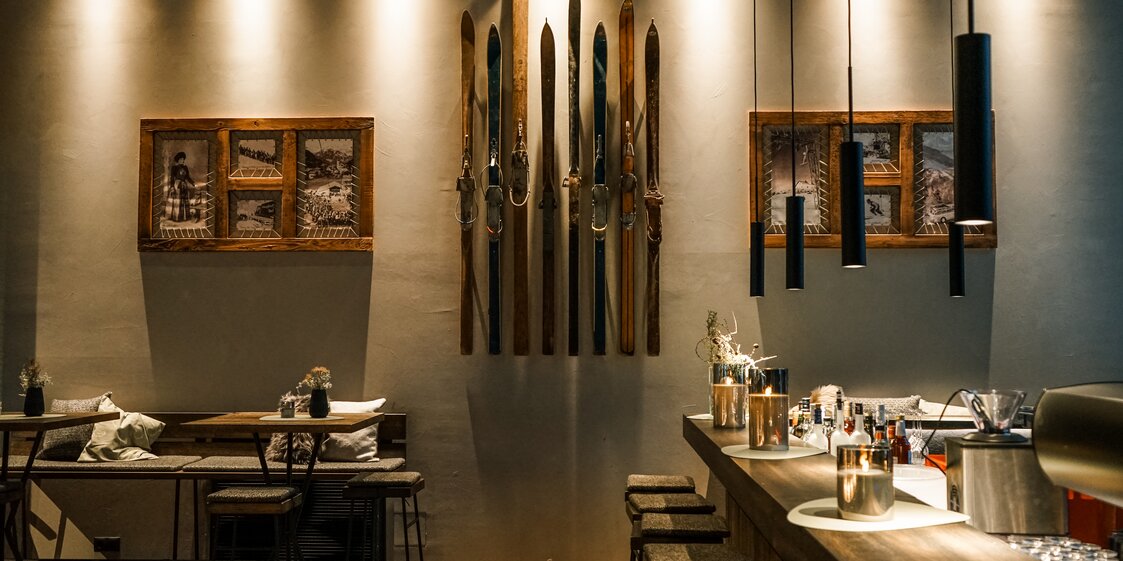 Ein Theke und ein Tisch im Restaurant, alte Ski hängen an der Wand. | © Silvretta Montafon - Vanessa Strauch