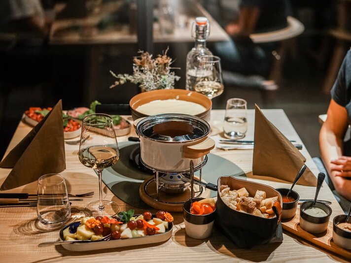 Ein gedeckter Tisch mit Käse- und Fleischfondue in der Silvretta Montafon. | © Silvretta Montafon - Vanessa Strauch