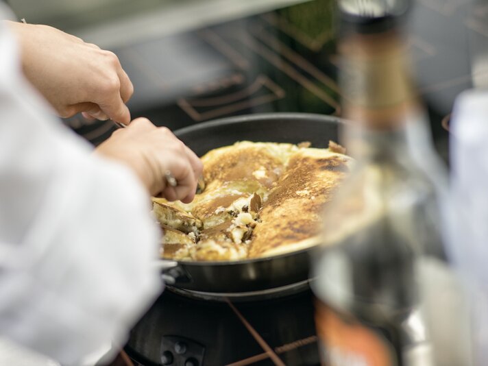 Ein Koch bereitet einen Kaiserschmarren in der Pfanne zu. | © Silvretta Montafon - Markus Gmeiner