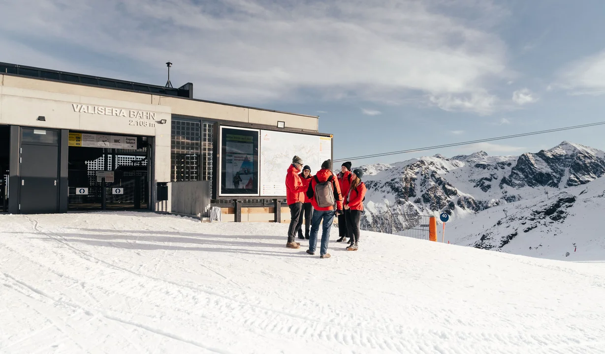 Audit Österreichisches Umweltzeichen | © Montafon Tourismus - Marie Rudigier Eine Gruppe von Personen in roten Skijacken im Skiegebiet an der Valisera Bahn Bergstation. | © Montafon Tourismus - Marie Rudigier